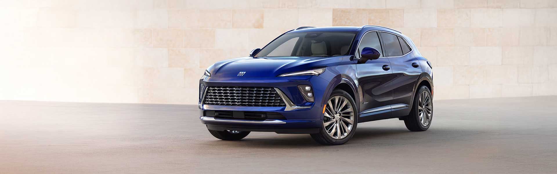 2025 Buick Envision compact luxury SUV in deep blue, shown in a studio setting with a sleek modern design