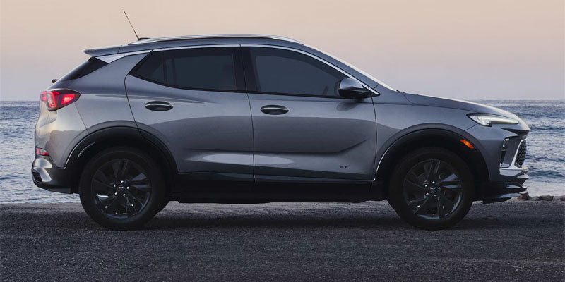 2026 Buick Encore GX parked on the beach, with waves and sand in the background, showcasing a scenic coastal view.